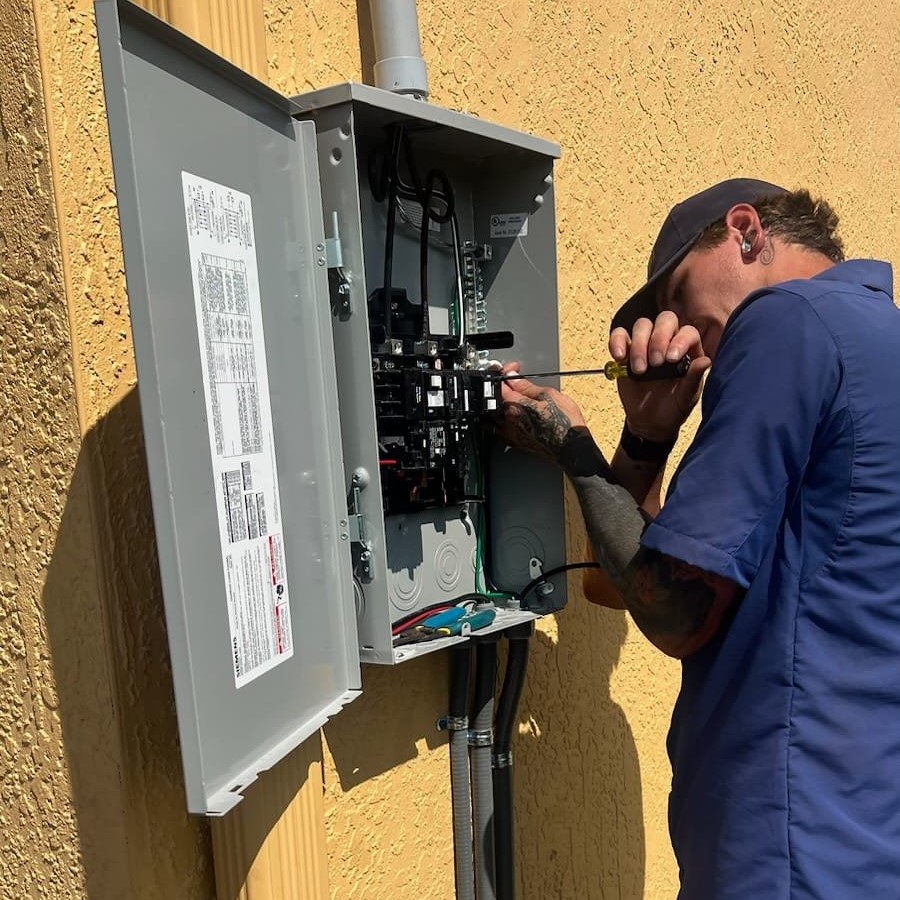 Hawkins Service Co electrician working on a home's exterior electrical panel