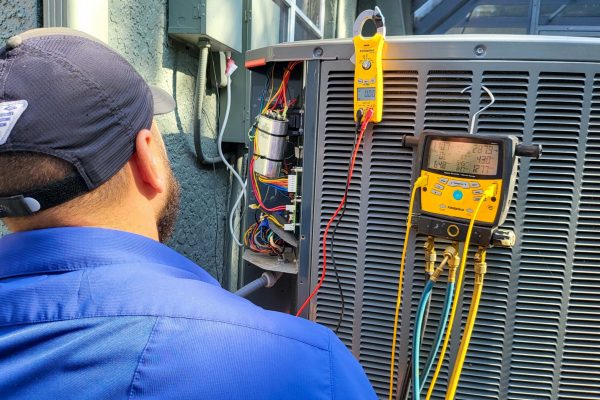 A technician looking at a ac unit condenser unit