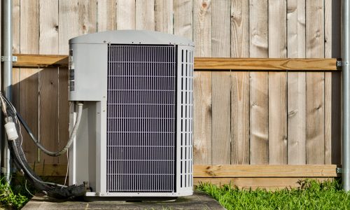 Central air conditioning unit in a residential backyard